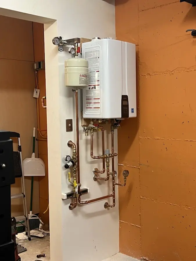 Plumbing technician inspecting water heater connections in Redwood Falls